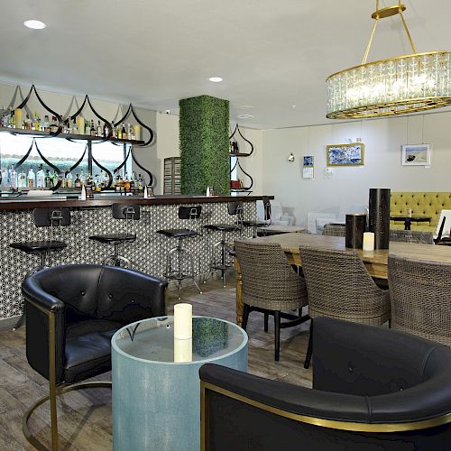 A modern lounge area with a stylish bar, green and yellow accents, various seating options, and elegant decor elements.