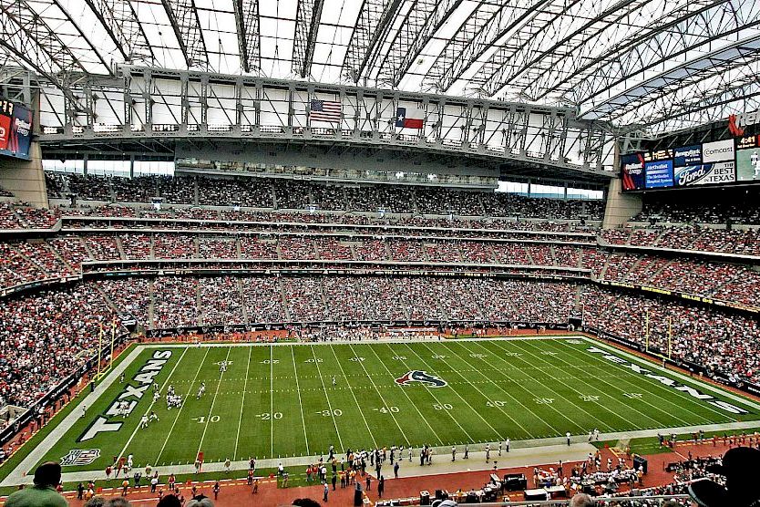 A large football stadium with a green field and seated crowd