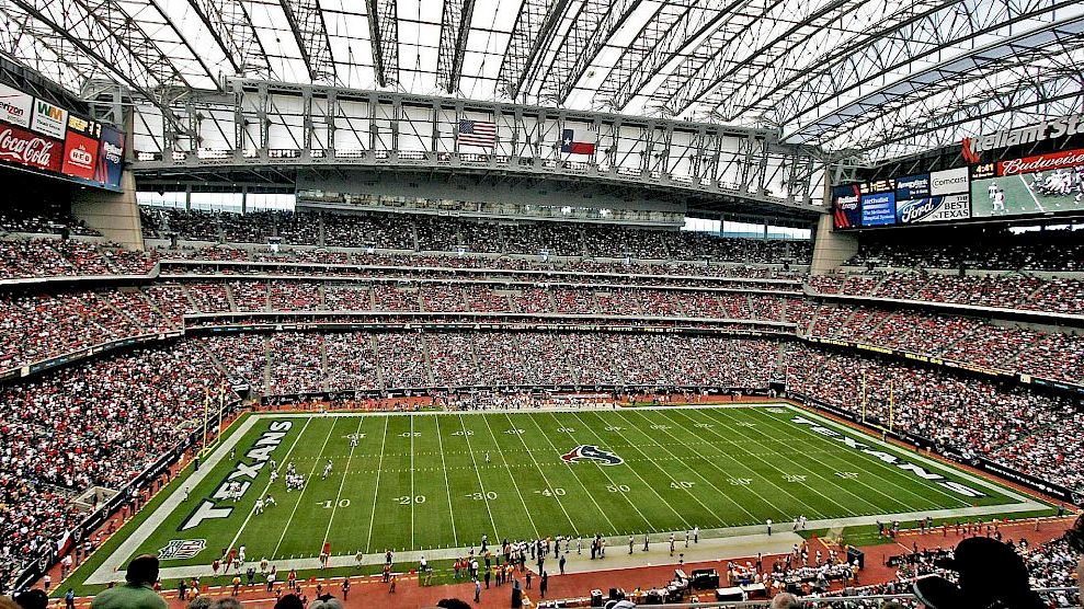 This image shows a packed football stadium with a view of the field and stands, covered by a retractable roof, likely during a game.